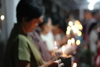 Women hold candles at a worship service in Indonesia 